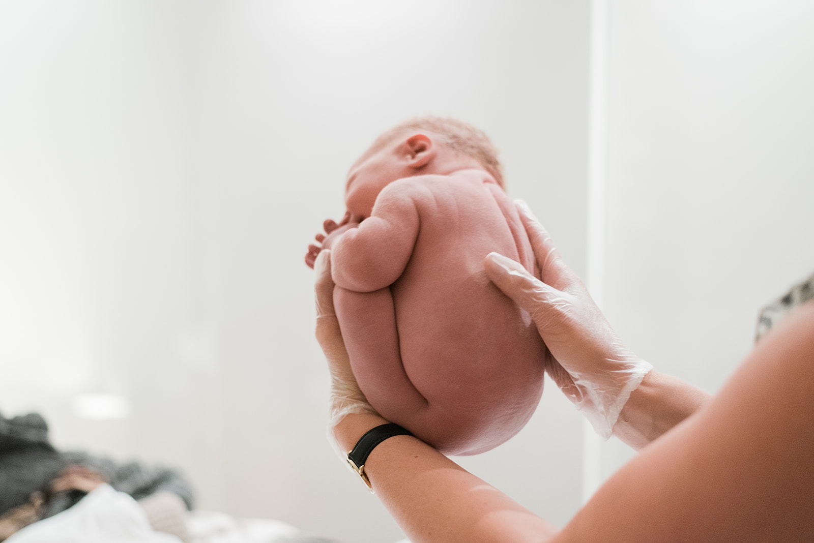 Een pasgeboren wordt in de wombpositie vastgehouden