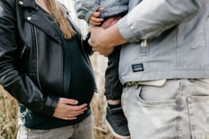 Een baby in de buik en een jongetje op vaders arm.