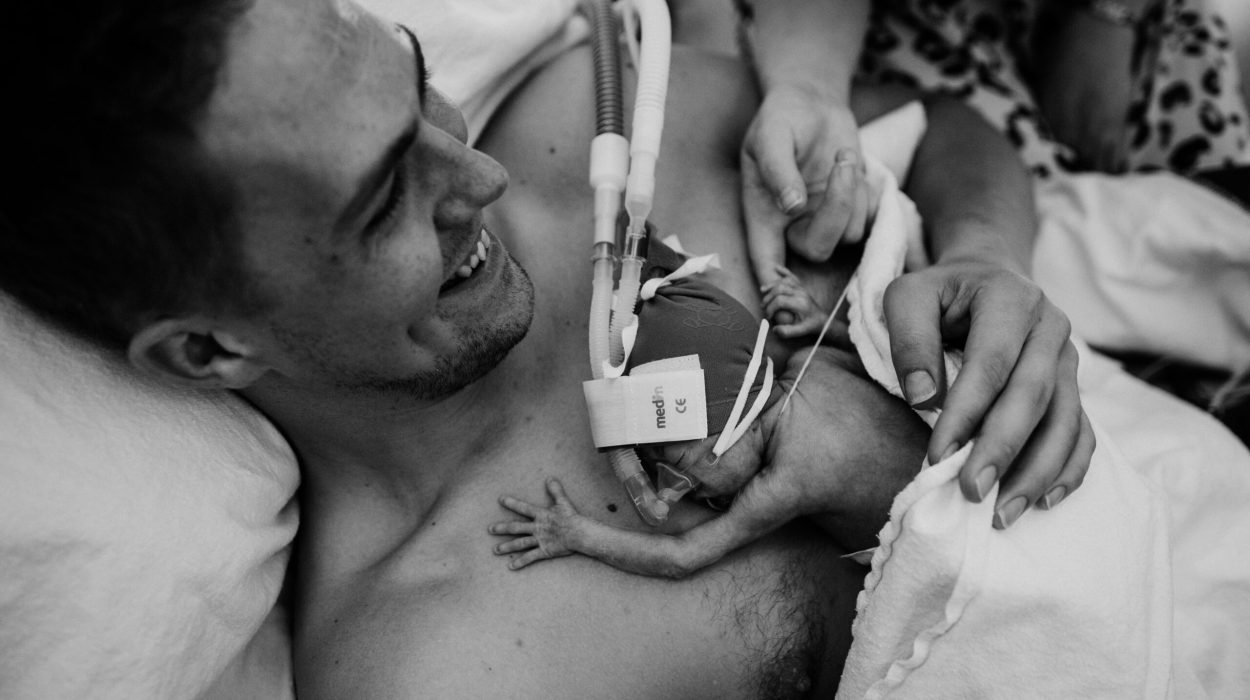 een baby met zuurstof ligt bij zijn vader